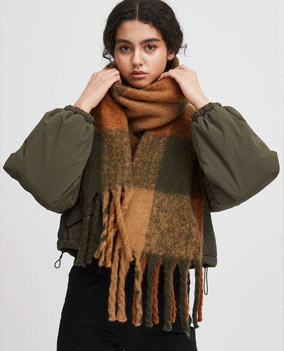 model in a green and brown checked oversized scarf 