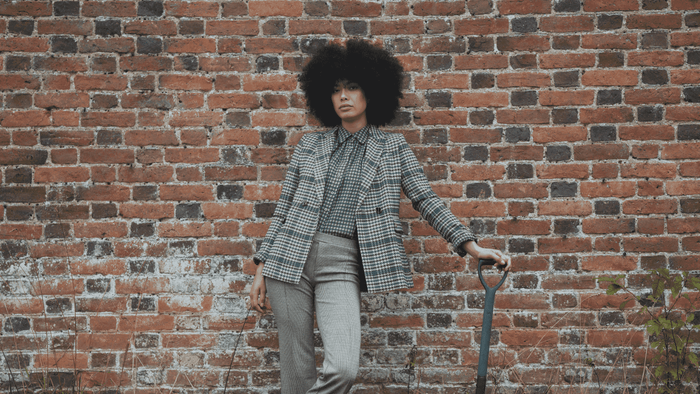 Model against brick wall wearing checks